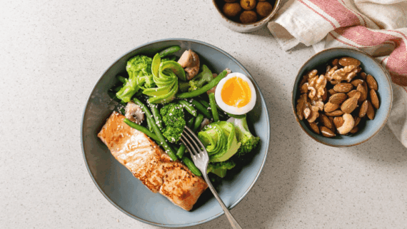 Aliments antiinflamatòris: un tall de salmó, verdures verdes, fruita seca i olives