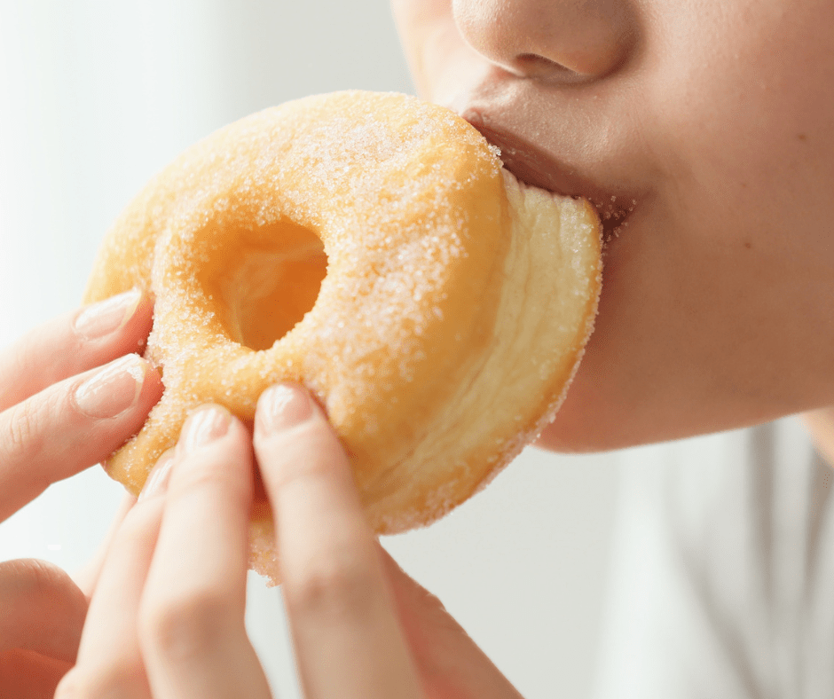 Noia menjant un dònut. El sucre té un impacte important en la salut