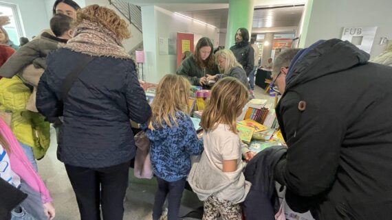 Dues nenes d'esquena en una parada de la Fira del llibre Infantil i Juvenil en català de Manresa