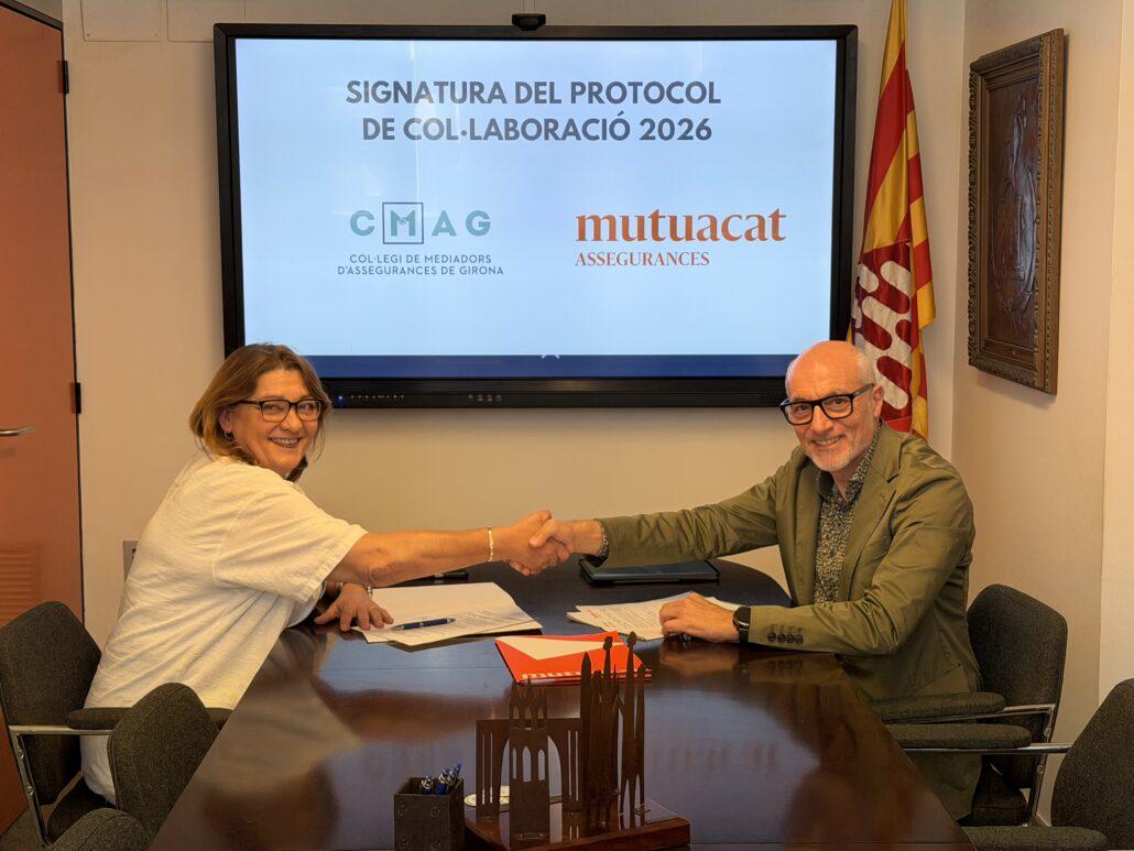 Mercè Herrera, presidenta del Col·legi de Mediadors d'Assegurances de Girona, i Leo Martínez, adjunt a la direcció General de Mutuacat, encaixen les mans deprés de signar el conveni de col·laboració