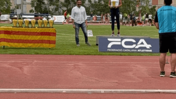 Una atleta al podi acaba de rebre el trofeu de mans del director general de Mutuacat, Sergi Macià, durant la 28a edició del Mítilng Internacional d'Atletisme Ciutat de Barcelona