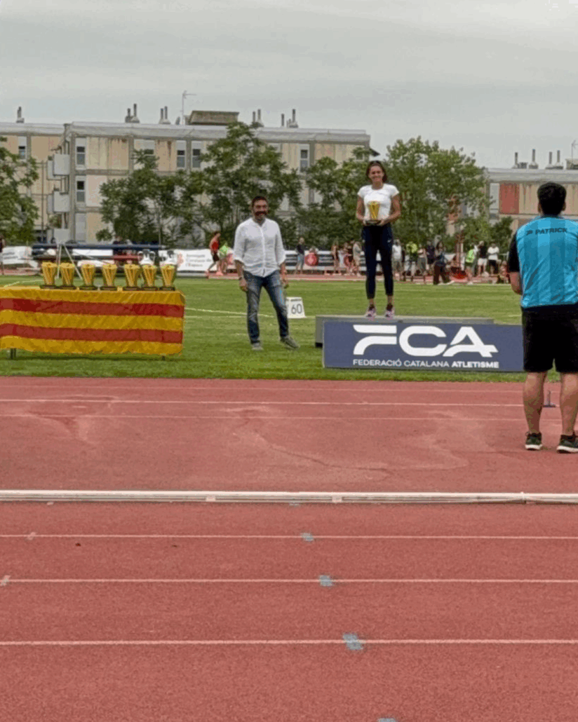 Una atleta al podi acaba de rebre el trofeu de mans del director general de Mutuacat, Sergi Macià, durant la 28a edició del Mítilng Internacional d'Atletisme Ciutat de Barcelona