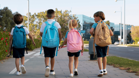 Infants que van a l'escola carregats amb la motxilla