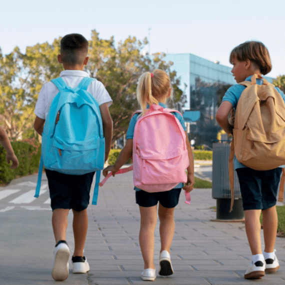 Infants que van a l'escola carregats amb la motxilla