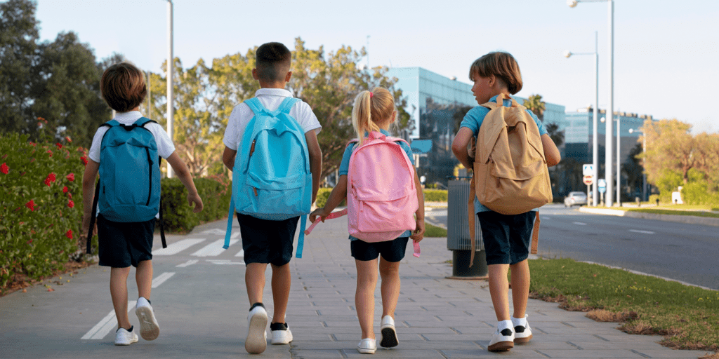 Infants que van a l'escola carregats amb la motxilla