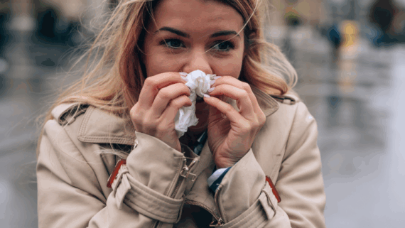 Una noia refredada en un carrer fred i humit