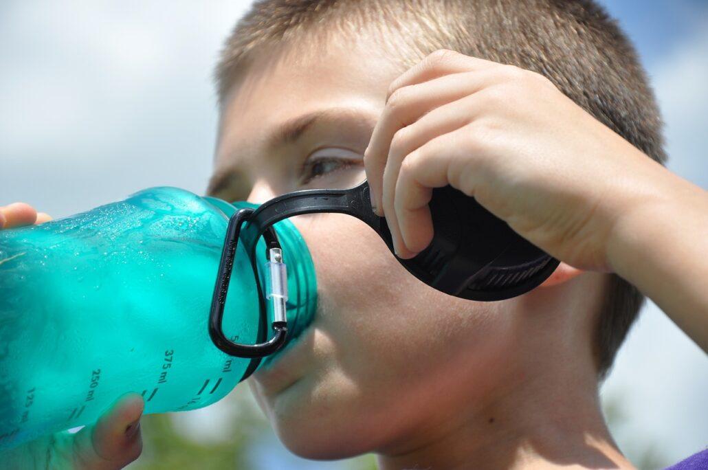 Nen que beu aigua per hidratar-se en un dia de calor
