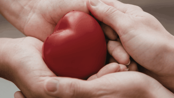 Mans sostenint un cor, metàfora del que és mutualisme, ètica i assegurances personals