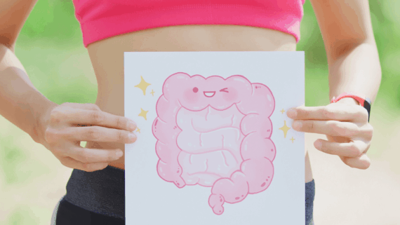 Dona que subjecta un cartell amb uns budells que somriuen perquè tenen una bona microbiota intestinal