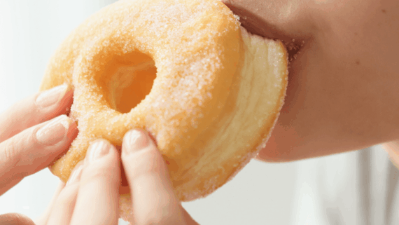 Noia menjant un dònut. El sucre té un impacte important en la salut