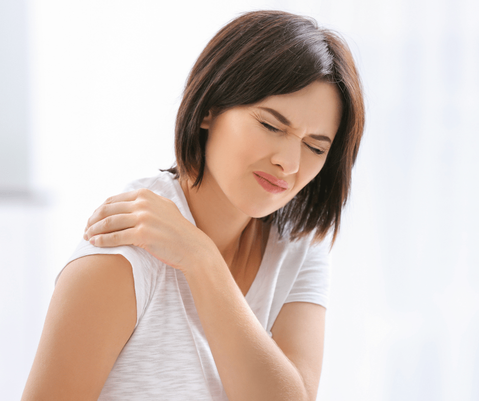 Una noia amb la mà a l'espatlla i amb cara de dolor. Probablementt pateix sinovitis