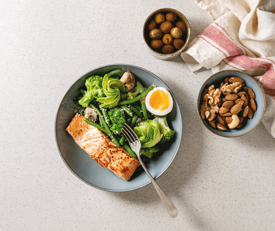 Aliments antiinflamatòris: un tall de salmó, verdures verdes, fruita seca i olives